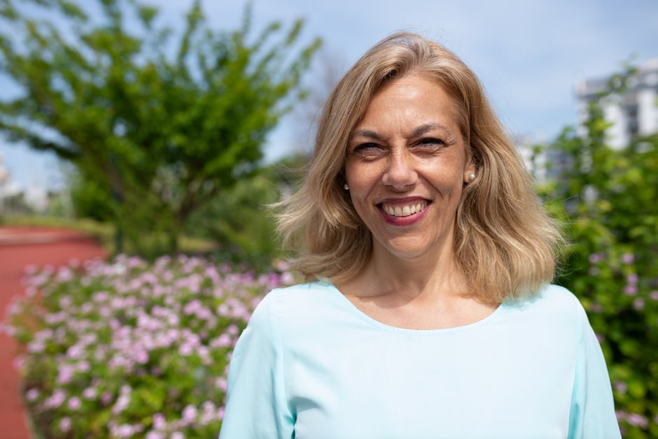 A woman in her fifties smiling outdoors